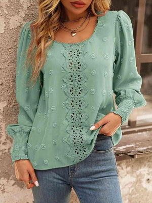 a woman wearing a green blouse and jeans