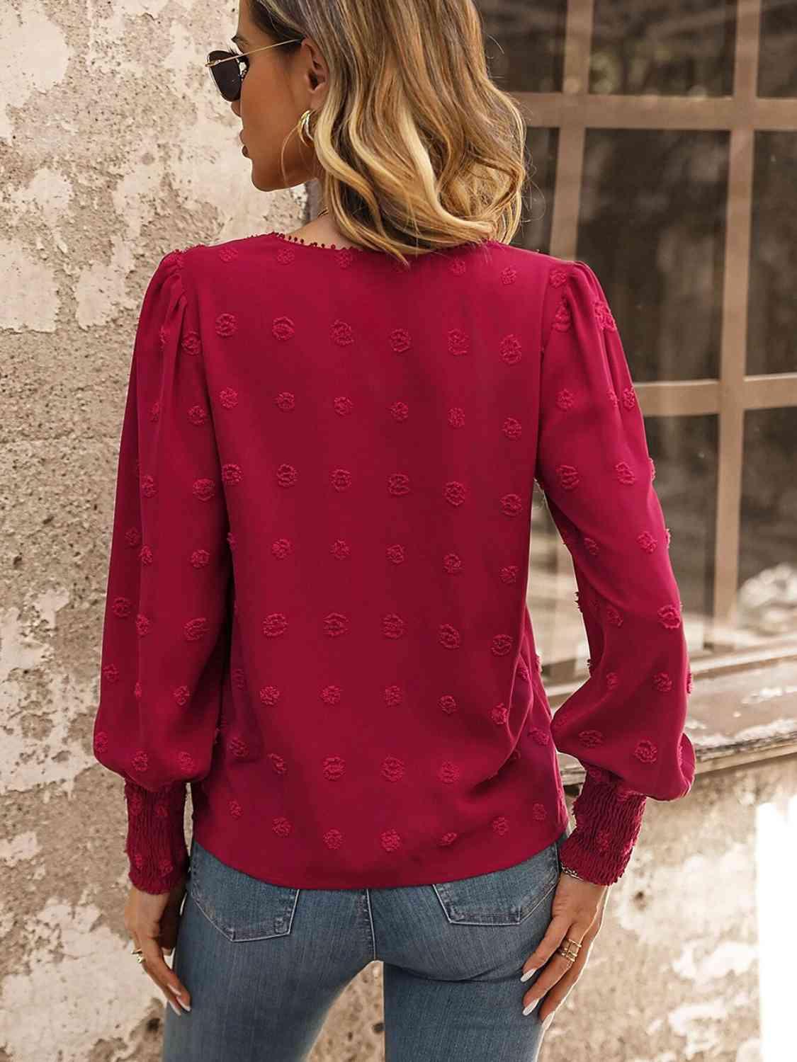 a woman wearing a red blouse and jeans