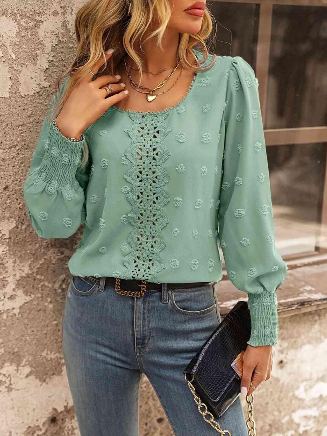 a woman wearing a green blouse and jeans