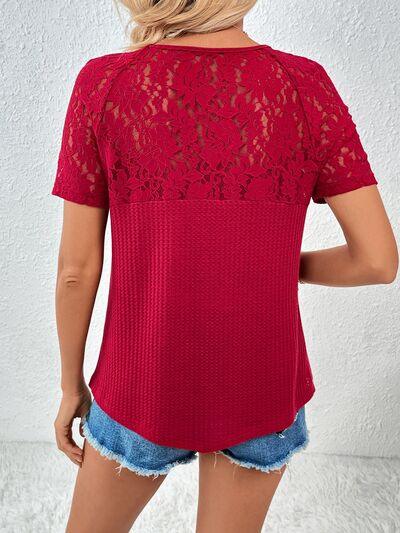 a woman wearing a red top with lace detailing