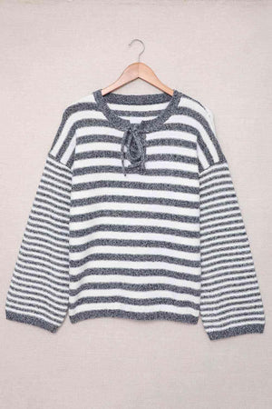 a white and black striped shirt hanging on a hanger