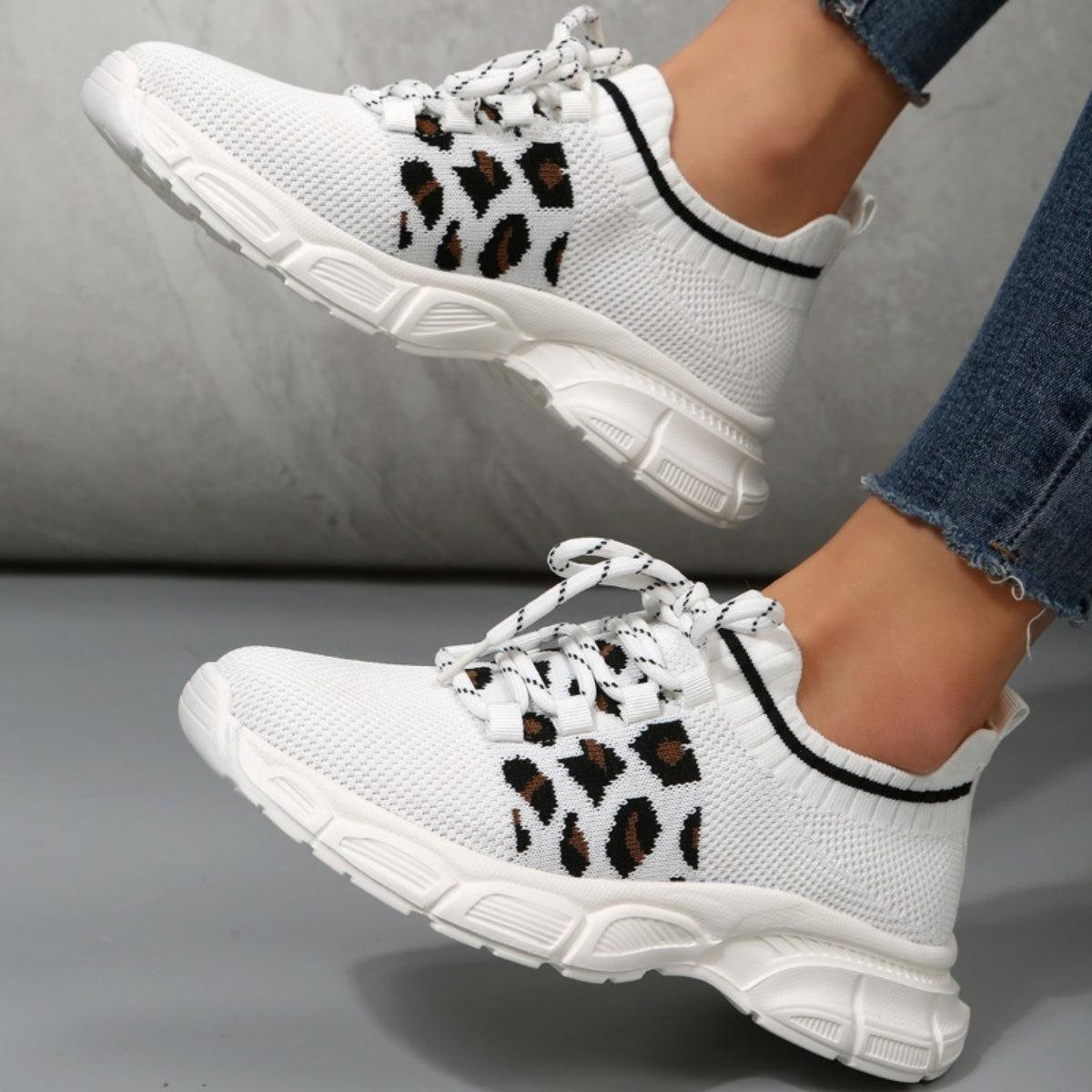 a woman wearing white sneakers with leopard print