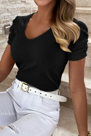 a woman in white pants and a black top