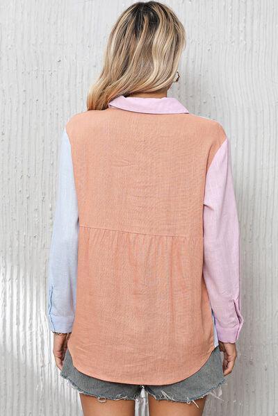 a woman standing against a wall wearing a pink and blue shirt