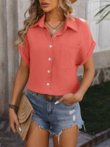 a woman wearing a red shirt and denim shorts