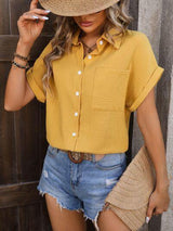 a woman wearing a yellow shirt and denim shorts