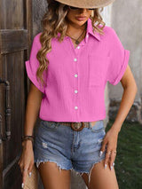 a woman wearing a pink shirt and denim shorts