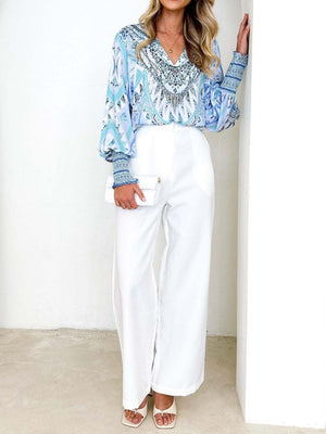 a woman in a blue top and white pants