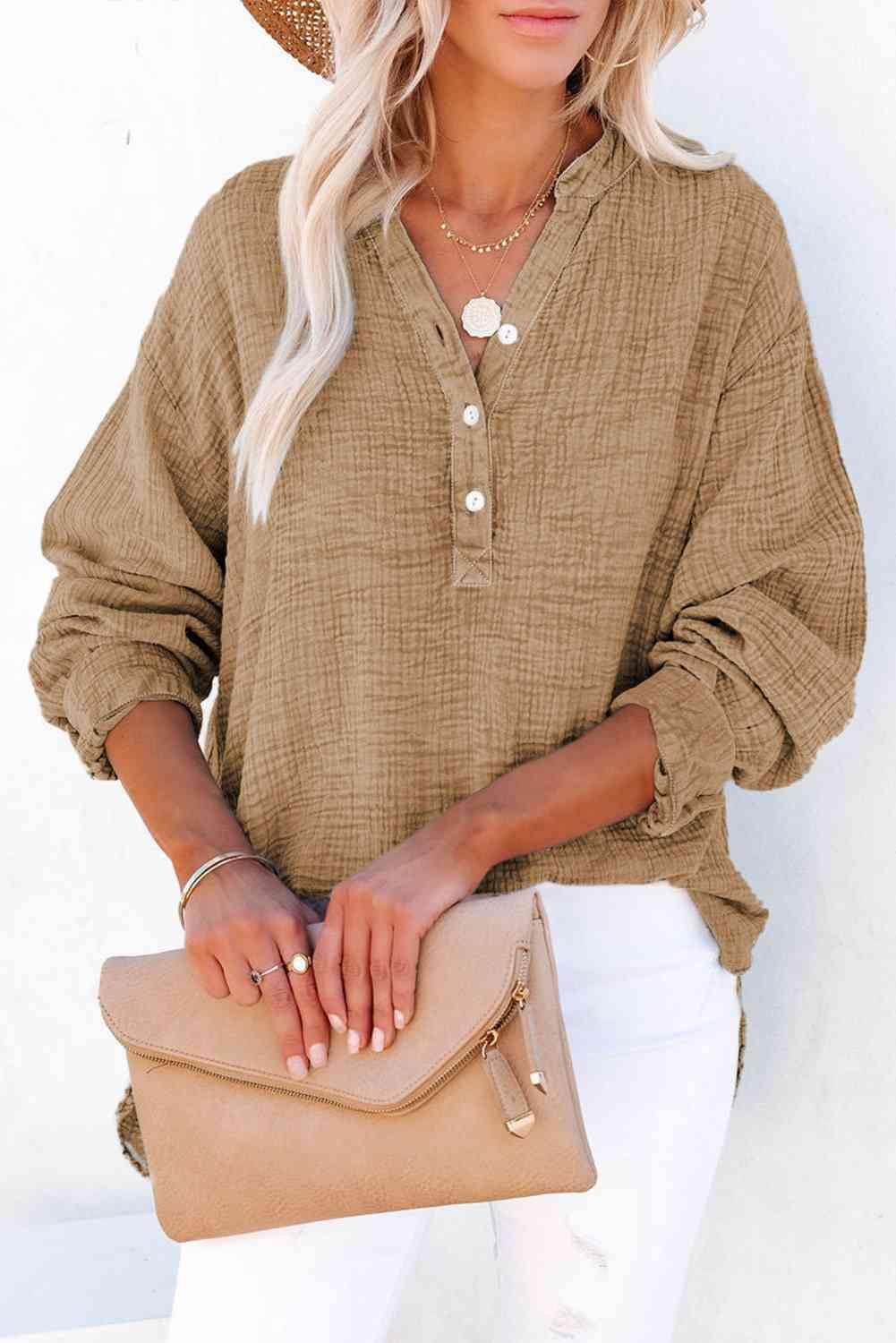 a woman wearing a straw hat and holding a tan purse