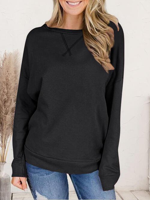 a woman wearing a black sweatshirt and jeans