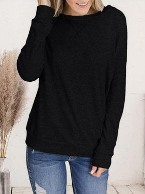 a woman wearing a black sweater and ripped jeans