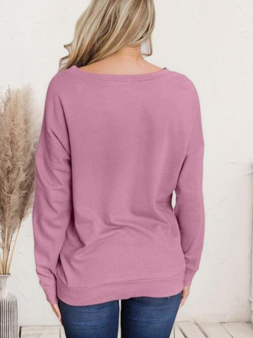 a woman wearing a pink sweater and jeans