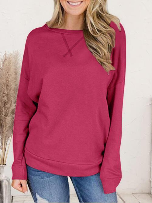 a woman wearing a pink sweater and jeans