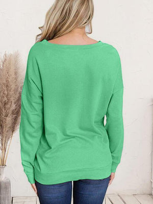 a woman wearing a green sweater and jeans