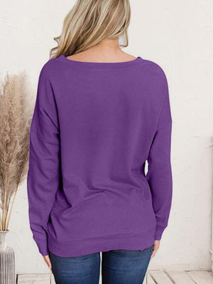 a woman wearing a purple sweater and jeans