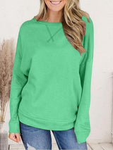 a woman wearing a green sweater and jeans