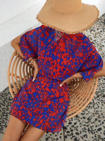 a woman in a red and blue dress sitting on a wicker chair