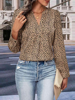 a woman wearing a leopard print shirt and jeans