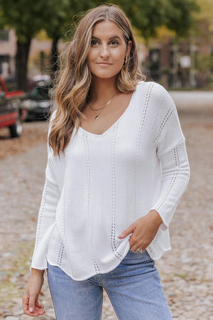 a woman wearing a white sweater and jeans