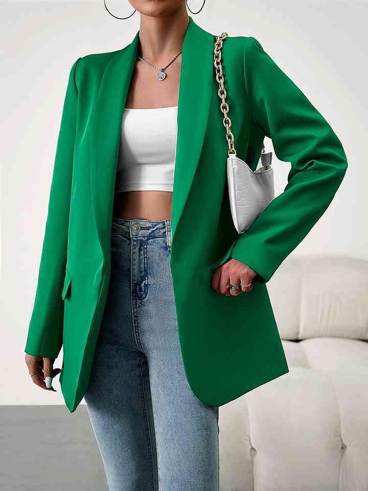 a woman wearing a green blazer and jeans