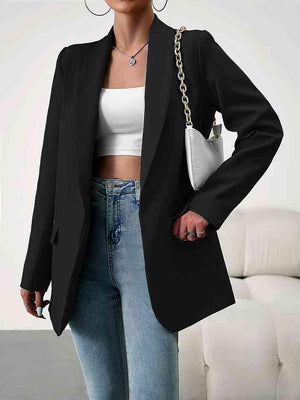 a woman wearing a black blazer and jeans