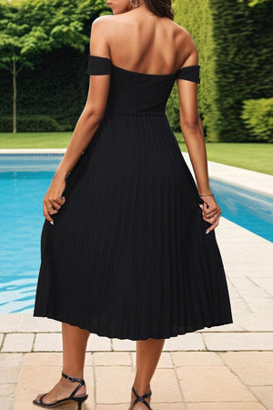 a woman standing in front of a pool wearing a black dress