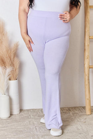 a woman in a white top and purple pants