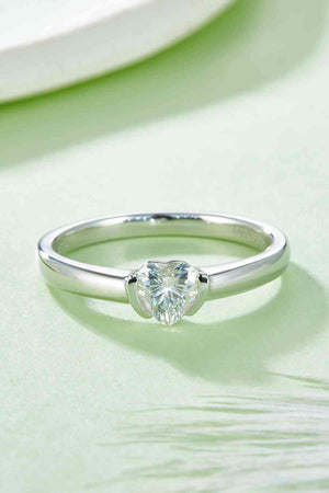 a heart shaped diamond ring on a table