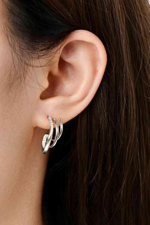 a close up of a person wearing a pair of earrings