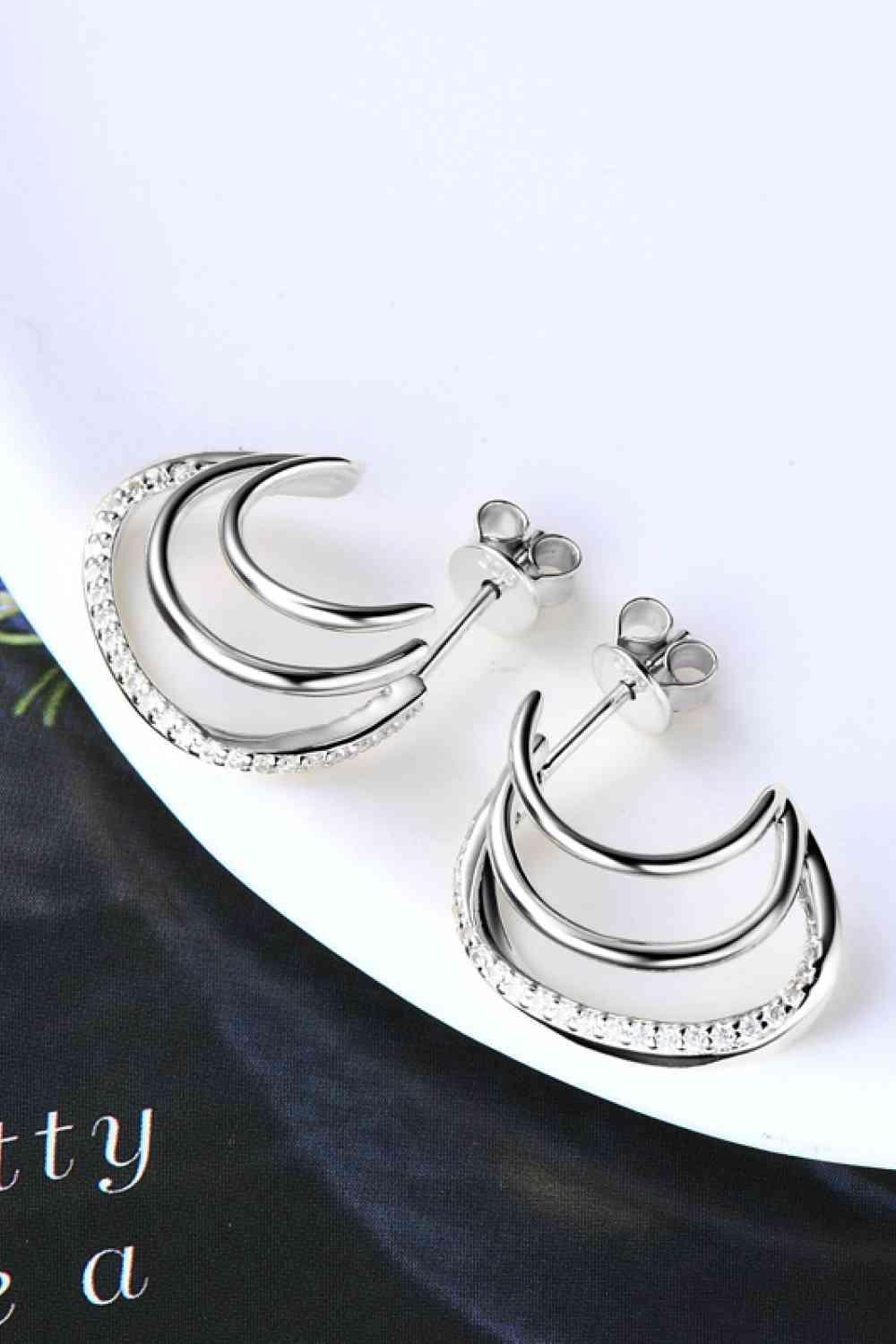 a pair of earrings with a crescent design