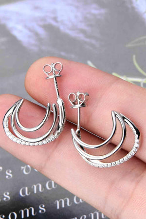 a person is holding a pair of earrings