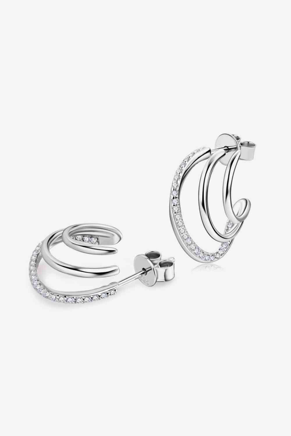 a pair of silver hoop earrings on a white background