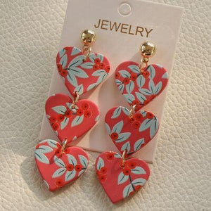 a pair of heart shaped earrings on a card