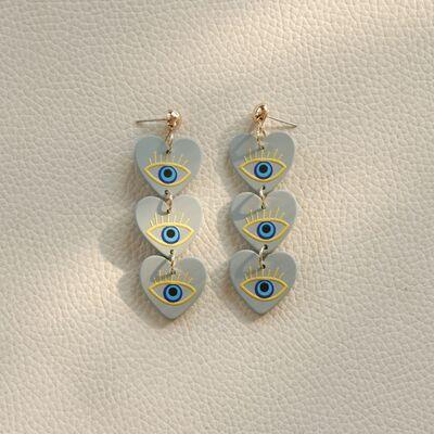 a pair of earrings with blue and yellow eyes