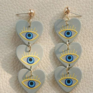 a pair of blue and yellow heart shaped earrings