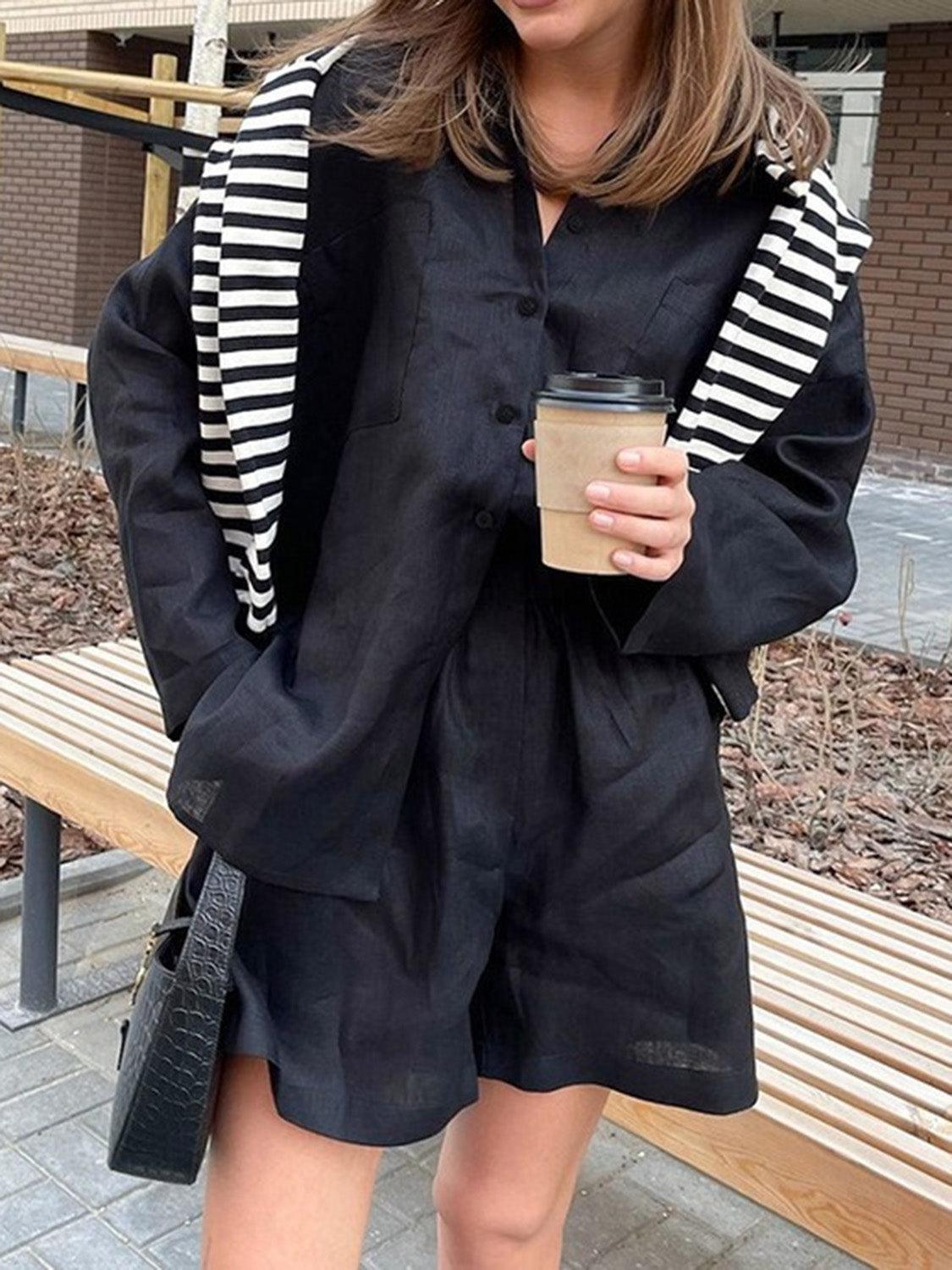 a woman standing on a sidewalk holding a cup of coffee