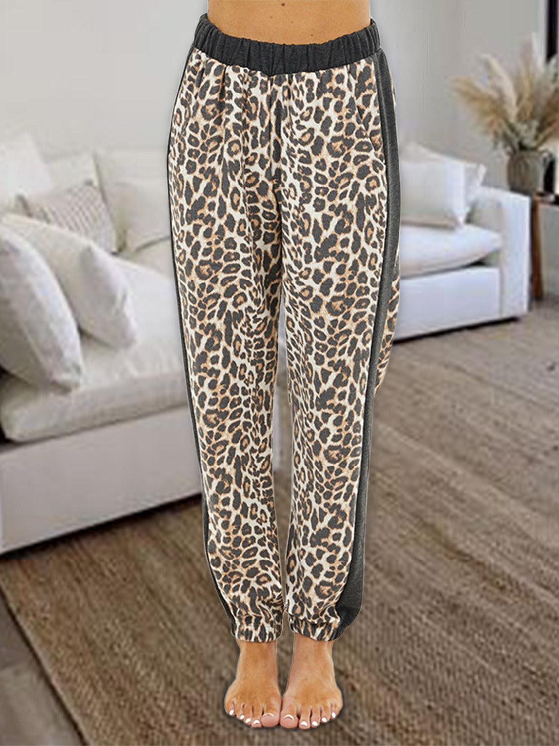 a woman standing in front of a couch wearing leopard print pants