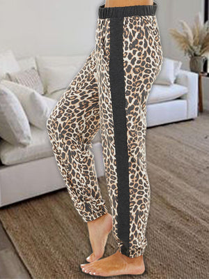 a woman standing in a living room wearing leopard print pants