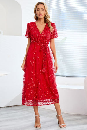 a woman in a red dress standing in front of a window