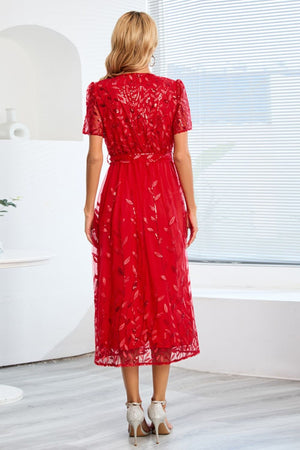 a woman in a red dress looking out a window