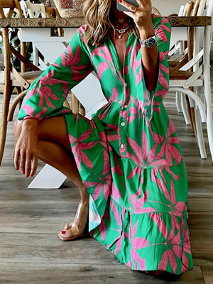 a woman sitting on the floor in a green and pink dress