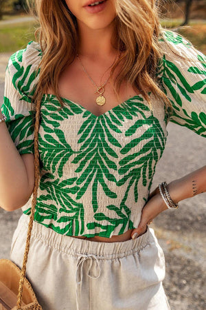 a woman in a green and white top holding a purse