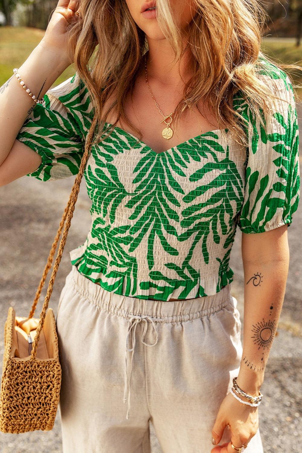 a woman wearing a green leaf print top