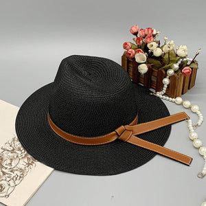 a black hat with a brown ribbon around the brim