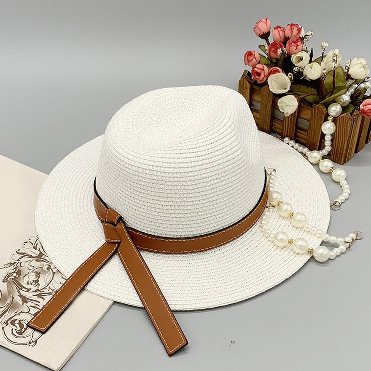 a white hat with a brown ribbon around it