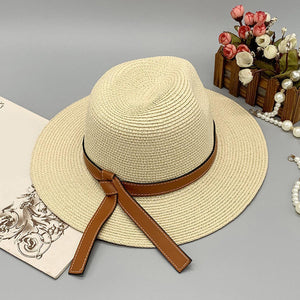 a white hat with a brown ribbon around the brim