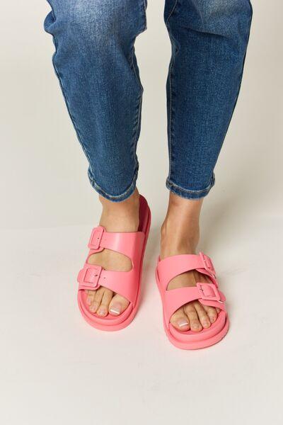 a woman wearing pink sandals and jeans
