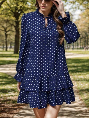 a woman walking down a path in a blue dress