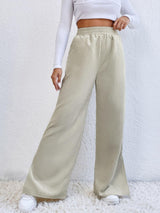 a woman in a white top and beige pants