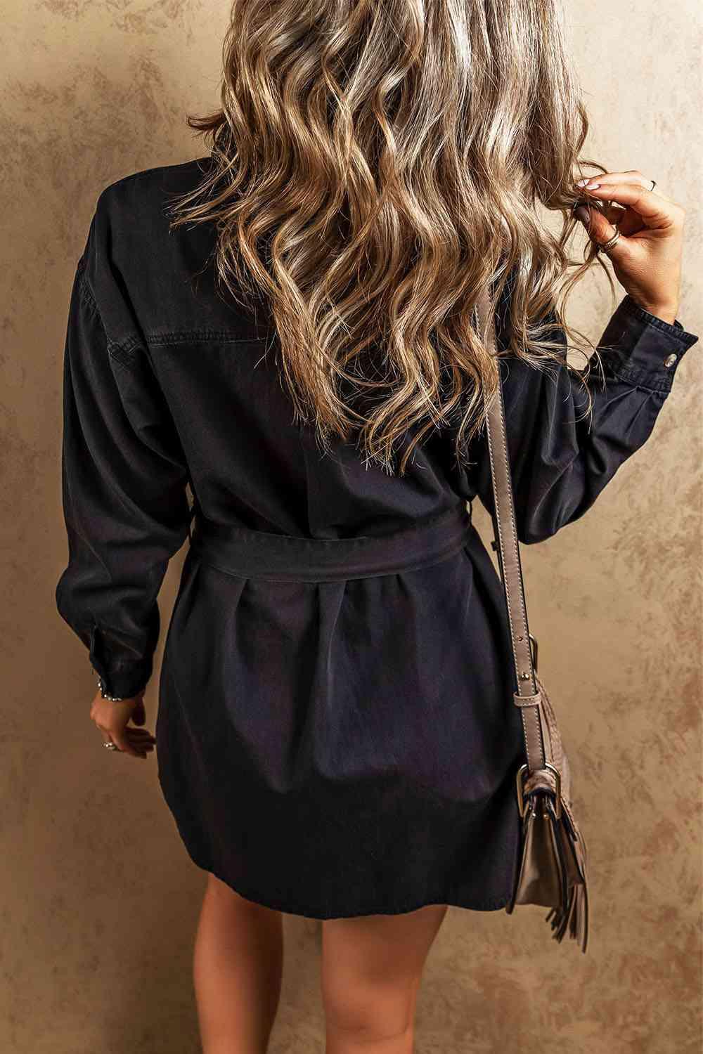 the back of a woman's head wearing a black shirt dress
